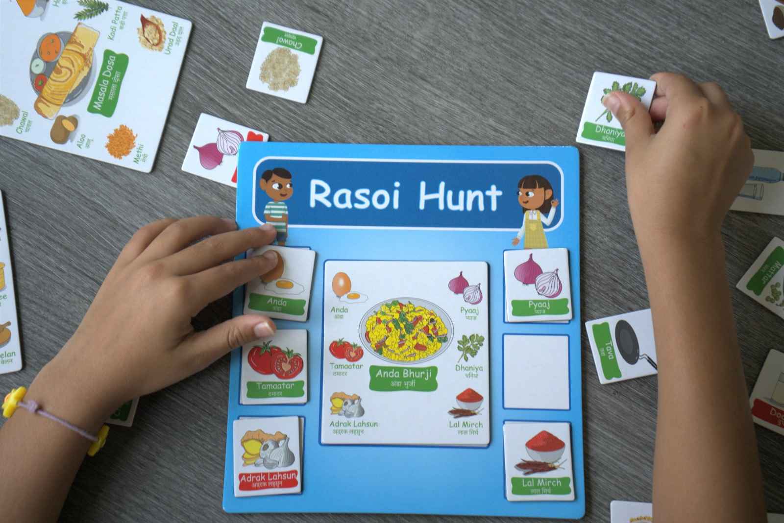 Child playing Rasoi Hunt game by PlayNSeekh which shows magnetic ingredients tiles collected to make anda bhurji (scrambled eggs) dish. 